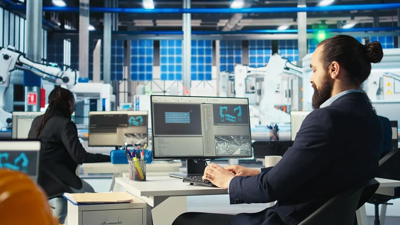 Esperto di una fabbrica fotovoltaica che ispeziona al computer i macchinari di un impianto solare.